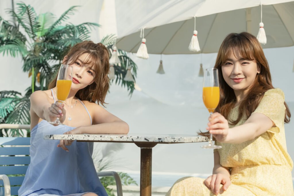 two girls offering orange juice